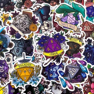 May include: A collection of colorful stickers featuring dice, flowers, and fantasy-themed illustrations. The stickers include text such as "Paladin", "Bard", and "That's Nice". The dice are numbered and decorated with various designs.