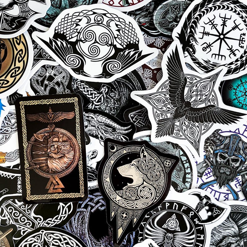 May include: A collection of black and white stickers featuring various Norse and Celtic designs. The stickers include images of wolves, ravens, runes, and other symbols.