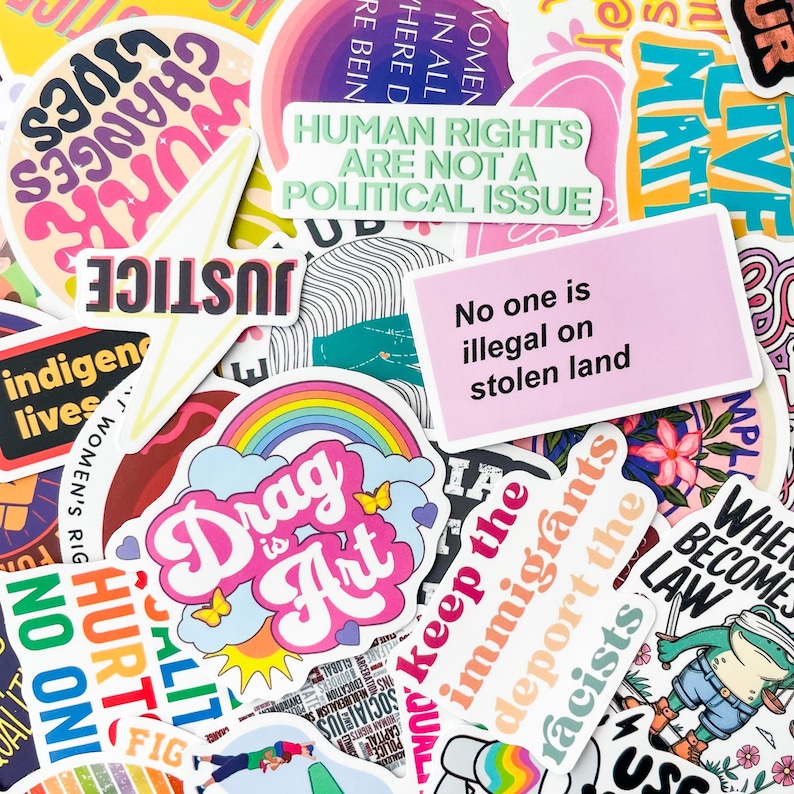 May include: A collection of colorful stickers with various text and graphic designs. The stickers feature phrases like "Human Rights Are Not a Political Issue," "Drag is Art," and "No one is illegal on stolen land."