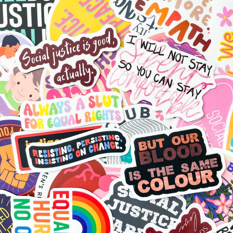 May include: A collection of colorful stickers with various text-based designs. The stickers feature phrases like "Social justice is good, actually," "Always a slut for equal rights," and "But our blood is the same colour." The stickers are diverse in shape and size.
