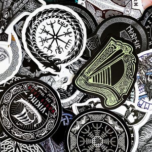 May include: A collection of black and white stickers with various designs, including a compass, a harp, and a Viking ship. The stickers are arranged in a random pattern and have a distressed, vintage look.