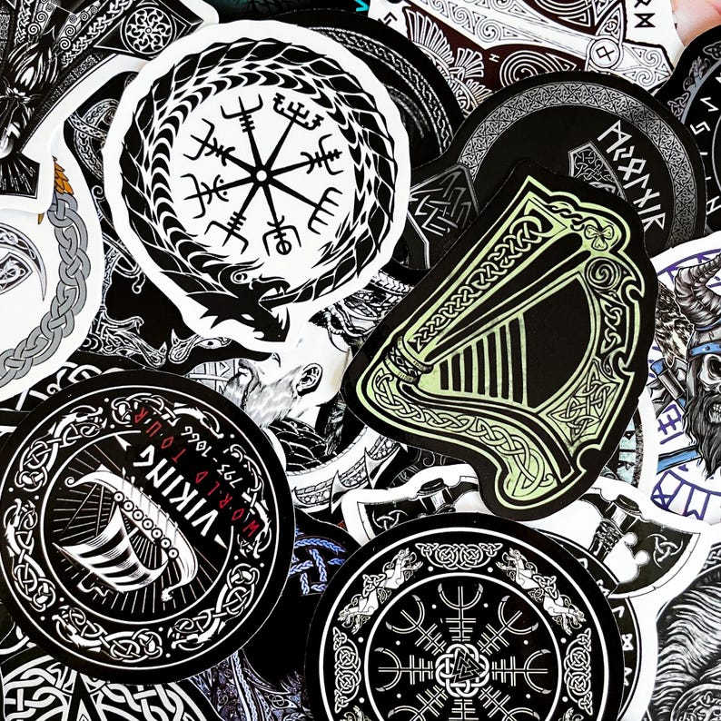 May include: A collection of black and white stickers with various designs, including a compass, a harp, and a Viking ship. The stickers are arranged in a random pattern and have a distressed, vintage look.