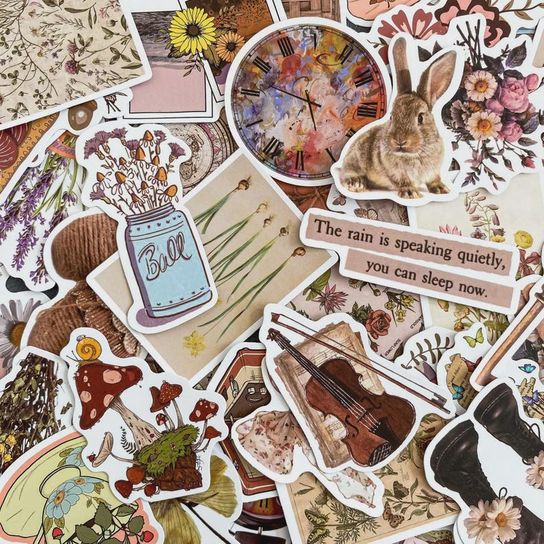 May include: A selection of vintage-style stickers featuring a rabbit, clock, flowers, a mason jar, a violin, and mushrooms. The text "The rain is speaking quietly, you can sleep now" is visible on one of the stickers.