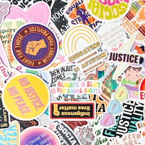 May include: A collection of colorful stickers with various designs and text. The stickers feature phrases like "No Justice, No Peace," "Educating is Activism," and "Indigenous Lives Matter." Other designs include a raised fist, a rainbow, and hearts.