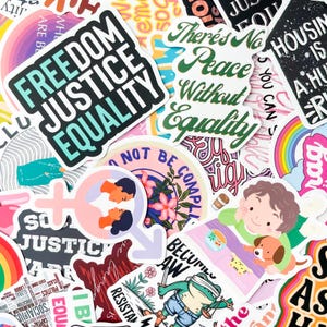 May include: A collection of colorful stickers with various designs and text. Some stickers feature phrases like "Freedom Justice Equality" and "There's No Peace Without Equality." Other stickers have illustrations of people, flowers, and a frog with a sword.