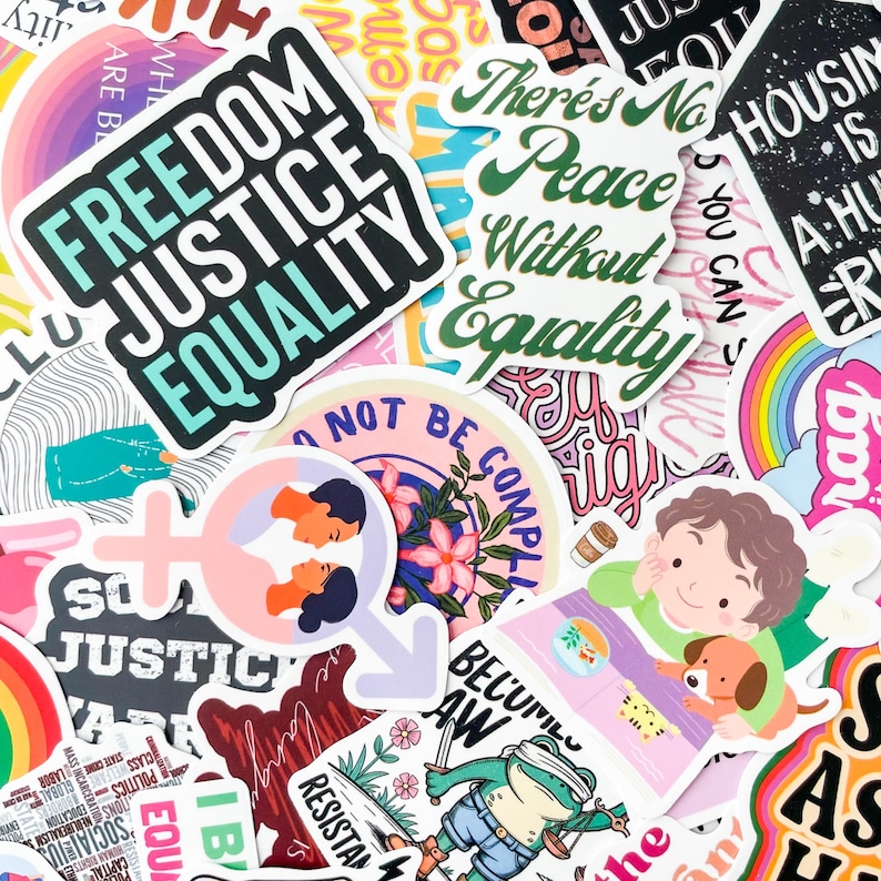 May include: A collection of colorful stickers with various designs and text. Some stickers feature phrases like "Freedom Justice Equality" and "There's No Peace Without Equality." Other stickers have illustrations of people, flowers, and a frog with a sword.