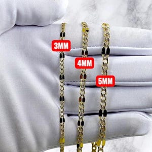 Op de afbeelding: Drie goudkleurige metalen kettingen met platte, langwerpige ovale schakels. De kettingen zijn voorzien van rode rechthoekige labels die breedtes van 3mm, 4mm en 5mm aangeven. De kettingen worden getoond tegen een witte stoffen achtergrond.