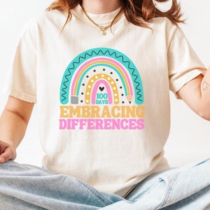 May include: A white t-shirt with a rainbow design and the text "100 Days Embracing Differences".