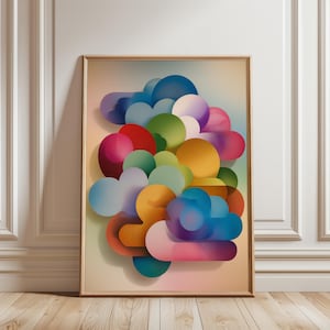 May include: Abstract art print featuring a cluster of colorful, rounded shapes in shades of blue, purple, red, green, and yellow. The artwork is framed in a light wood frame and leans against a white wall. The shapes appear to be layered, creating a 3D effect.