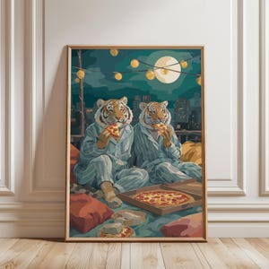 May include: A framed art print depicts two tigers in pajamas enjoying pizza on a rooftop at night. The artwork features a full moon, city skyline, and string lights, with a pizza box and pillows.