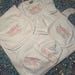 May include: A white baby clothing set featuring a blanket, bib, hat, and long-sleeved onesie. Each item is embroidered with a pink bow and the name "Ellie Rae". The set has pink trim.