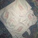 May include: A white baby clothing set with pink embroidered details. The set includes a blanket, bib, hat, and long-sleeved shirt. Each item features the name "Ellie Rae" and a bow design.