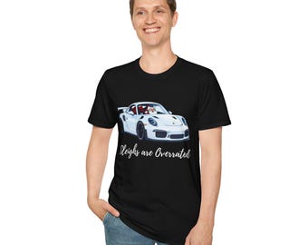 May include: A black t-shirt featuring a graphic of a white sports car with a Santa Claus figure in the driver's seat. Below the car, the text reads "Sleighs are Overrated" in a white cursive script font. The shirt has a crew neckline.