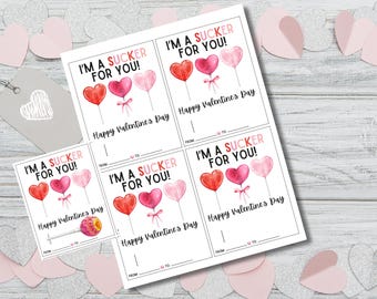 May include: Four printable Valentine's Day gift tags featuring a watercolor illustration of three heart-shaped lollipops with the text "I'm a sucker for you!" and "Happy Valentine's Day".
