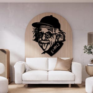 May include: Black and white silhouette of Albert Einstein wearing a cap and sticking his tongue out. The text "E=MC2" is on the right side of the image. The silhouette is mounted on a wooden background.