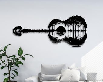 Puede incluir: Silueta negra de una guitarra acústica con una puesta de sol y árboles dentro del cuerpo de la guitarra. La guitarra se refleja en un cuerpo de agua.