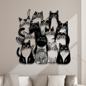 May include: Black metal wall art featuring a group of cats in various poses. The cats are all stylised and have different facial expressions. The art is perfect for adding a touch of whimsy to any room.