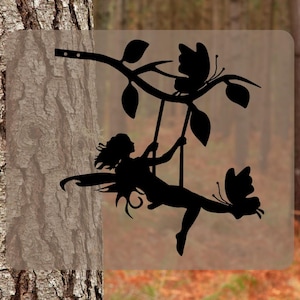 May include: Black metal silhouette of a fairy swinging on a branch with two butterflies. The fairy has long hair and wings. The branch has leaves and is attached to a wall.
