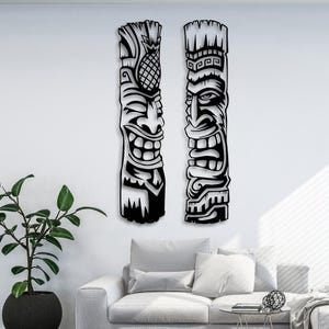 Peut inclure: Deux décorations murales en forme de masque tiki noir et blanc. Les masques sont sculptés avec des détails complexes et présentent un design hawaïen traditionnel.