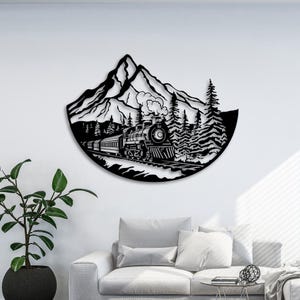 May include: Black metal wall art depicting a train traveling through a mountain landscape. The train is a steam engine with a plume of smoke coming from the chimney. The mountain is in the background with trees on either side of the train.