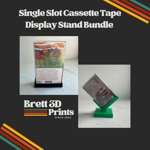 May include: A single slot cassette tape display stand bundle featuring two stands. One stand is black and holds a Beach Boys cassette tape upright. The other stand is green and holds a cassette tape at an angle. Text reads Single Slot Cassette Tape Display Stand Bundle and Brett 3D Prints Since 2024.