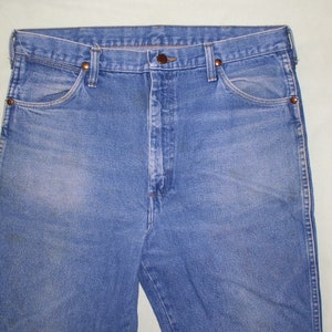 May include: A pair of blue denim jeans with a button fly and belt loops. The jeans have a faded look and are made of a soft, comfortable material.