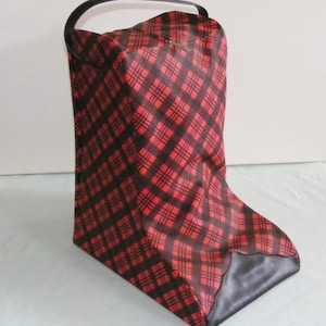 May include: A red and black plaid patterned bag with a black handle and a black bottom. The bag is rectangular with a curved top and a handle. The plaid pattern is a classic design.