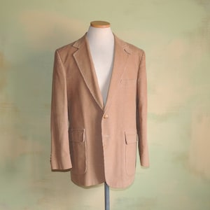 May include: A brown corduroy blazer with a single button closure and two flap pockets.