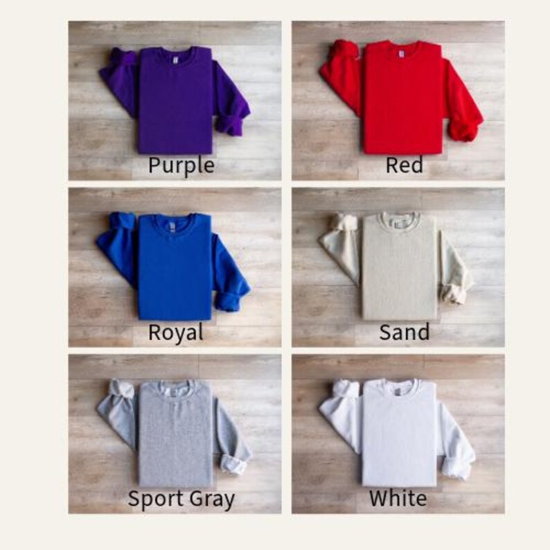 K&ouml;nnte beinhalten: Sechs verschiedene farbige Sweatshirts liegen flach auf einer Holzoberfl&auml;che. Die Farben sind lila, rot, royalblau, sand, sportgrau und wei&szlig;.