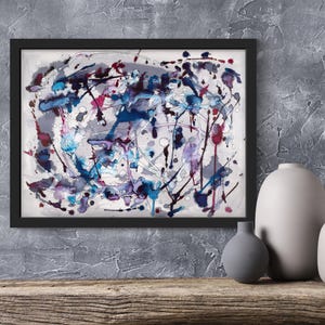 May include: Abstract art print in a black frame. The artwork features a watercolor design with splashes of blue, purple, and red on a white background. The painting is displayed on a wooden shelf with three ceramic vases.
