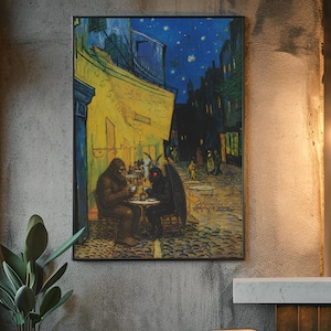 May include: A framed wall art print featuring a dark, starry night scene with a yellow cafe building. A brown Bigfoot and a black Mothman sit at a small round table on a cobblestone street, drinking from white cups under a deep blue sky.