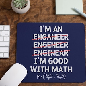 Puede incluir: Una alfombrilla de ratón rectangular de color azul oscuro con texto blanco que dice I'M AN ENGA-NEER, ENGENEER, ENGINEER, I'M GOOD WITH MATH, con las tres primeras palabras tachadas por líneas rojas y una fórmula matemática al pie.