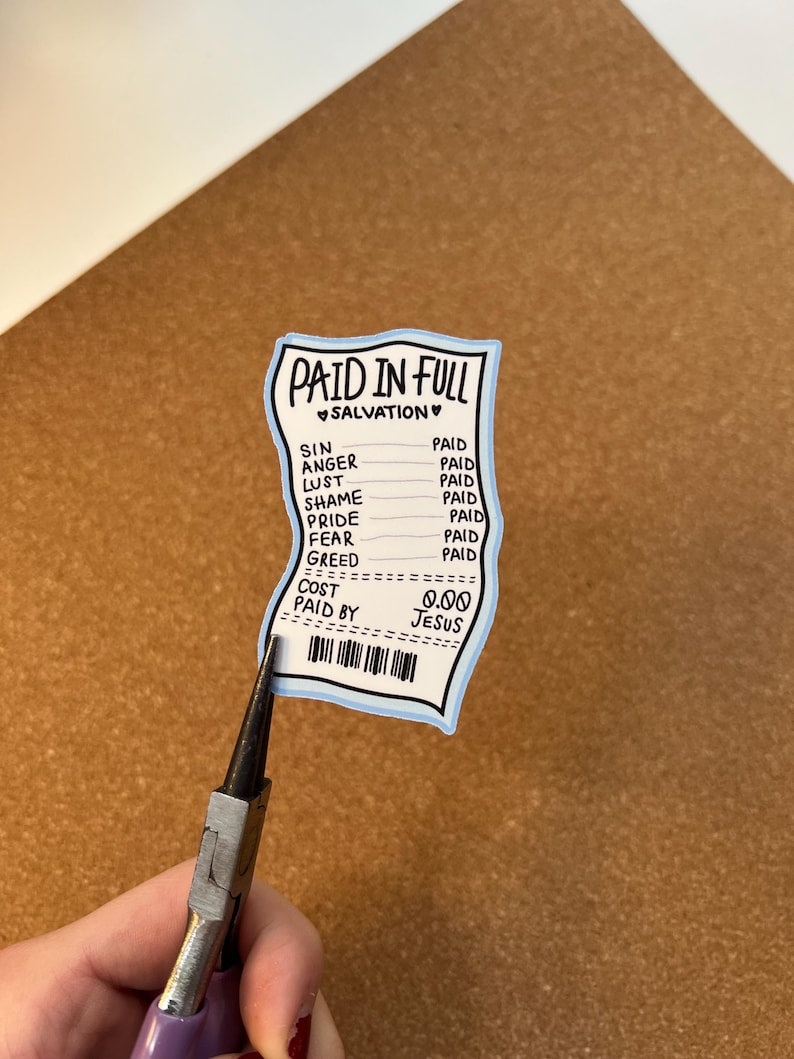 May include: A sticker in the shape of a receipt with the words "PAID IN FULL" and "SALVATION" at the top. The receipt lists "SIN, ANGER, LUST, SHAME, PRIDE, FEAR, GREED" with "PAID" next to each. The cost is listed as "0.00" and "PAID BY JESUS".