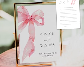 May include: A framed sign and matching card set with a watercolor pink bow design. The sign reads "Advice and Wishes" and "For the soon-to-be Mrs. Farmer." The matching card is for advice to the bride.