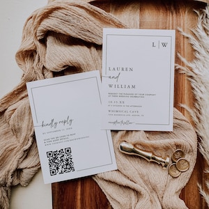 以下が含まれることがあります： 「Lauren and William」と「Kindly Reply」の文字が黒で書かれた2枚の白い結婚式の招待状。 金色のワックスシールとコインが、ベージュの布が敷かれた木製の表面に置かれています。