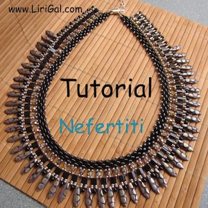 Op de afbeelding: Een zwarte en zilveren kralenketting met een geometrisch ontwerp. De ketting is gemaakt met kleine, vierkante kralen en lange, puntige kralen. De ketting heet "Nefertiti" en is een tutorial.