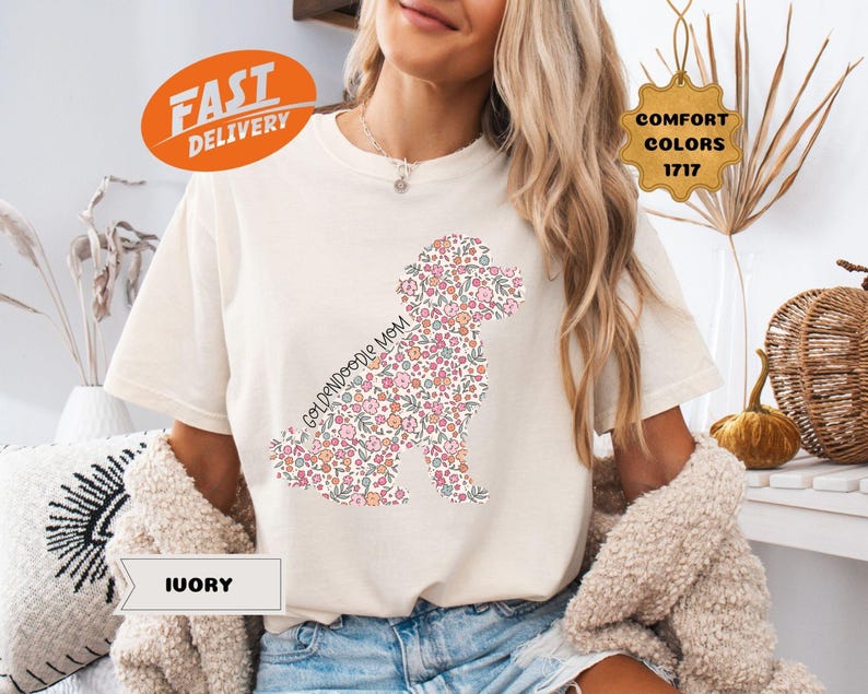 May include: A white t-shirt with a floral goldendoodle silhouette and the text "Goldendoodle Mom".