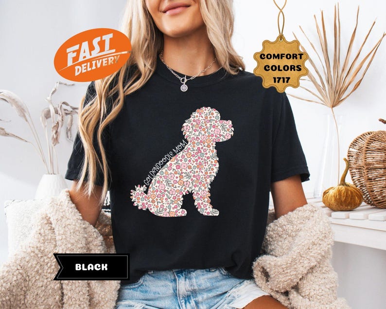 May include: Black t-shirt with a floral doodle of a poodle and the text "Goldendoodle Mom".