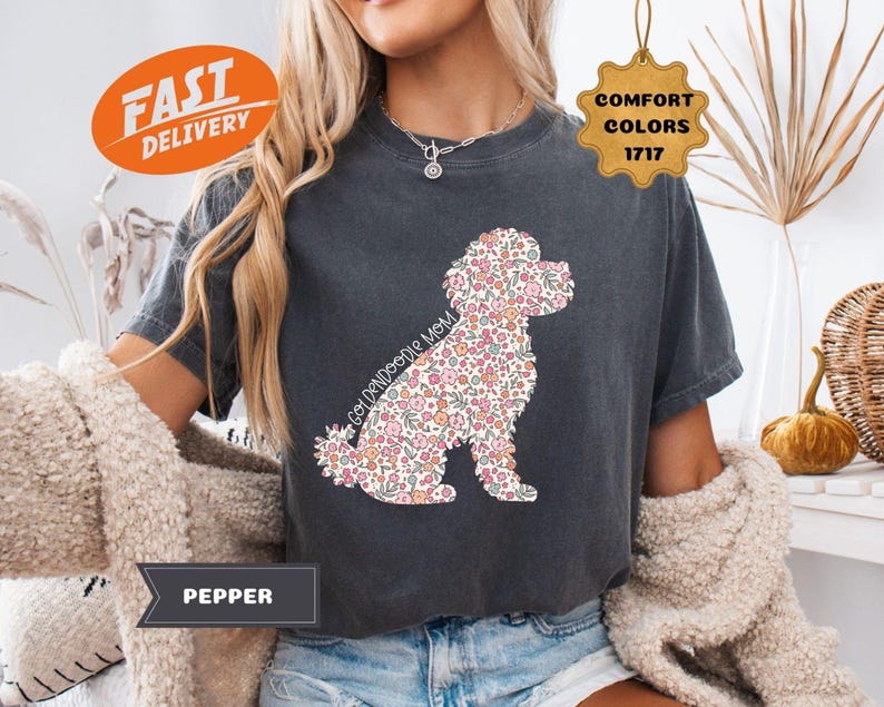 May include: A dark gray t-shirt with a floral doodle of a Goldendoodle dog. The shirt has the text "Goldendoodle Mom" on it.