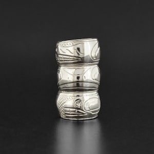 May include: Three silver rings stacked on top of each other. Each ring features a unique design of a stylized animal face.
