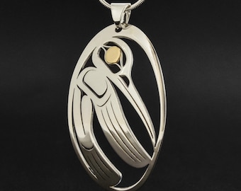 May include: Silver pendant necklace featuring a stylized hummingbird design with a gold accent. The pendant is oval shaped and hangs from a silver chain.