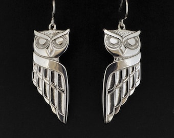 May include: A pair of silver owl earrings with detailed wings and a textured finish.