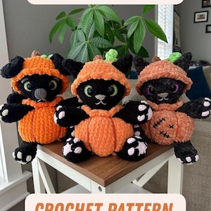 May include: Three handmade crochet black cat plushies wearing orange pumpkin costumes. The plushies have green eyes and white paws. The text "STITCHES & BONES" and "CROCHET PATTERN" are displayed above and below the plushies.