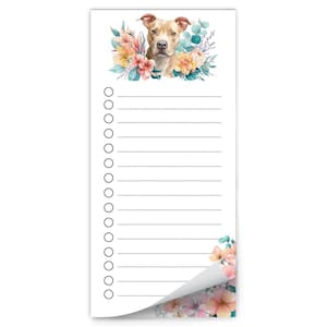 May include: White notepad with a watercolor illustration of a tan and white dog surrounded by colorful flowers. The notepad has a lined section for writing and a decorative floral corner.