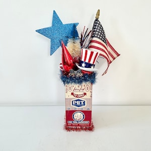 Vintage patriotic assemblage arrangement Memorial Day July 4 Labor Day 48 star flag Uncle Sam hat bottlebrush tree in PET milk carton