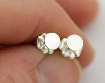 Op de afbeelding: Een paar zilveren oorbel studs met ronde, gladde, platte voorkanten.