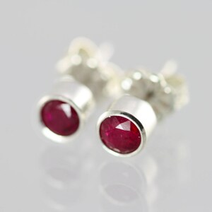 Puede incluir: Un par de pendientes de plata con piedras preciosas de rubí rojo.