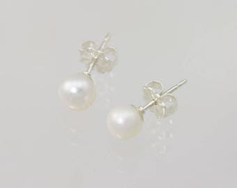 Puede incluir: Un par de pendientes de plata con detalles de perlas blancas.