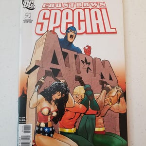 Może przedstawiać: Okładka komiksu "Countdown Special" nr 2, z Atomem, Wonder Woman i Aquamanem. Okładka przedstawia postacie w dramatycznej scenie z odważnymi kolorami i dynamicznymi pozami. Widoczne jest logo DC Comics.