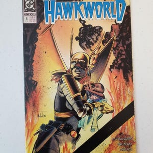 Może przedstawiać: Okładka komiksu Hawkworld przedstawiająca postać w kostiumie trzymającą dziecko na tle ognia. Tytuł "HAWKWORLD" jest wyraźnie widoczny. Widoczny jest r&oacute;wnież numer 4 i logo DC Comics.